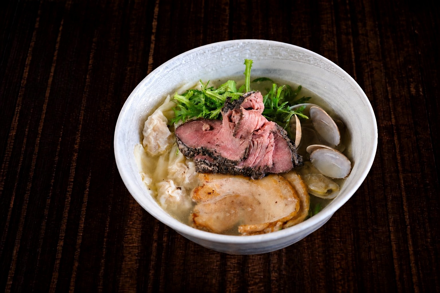 本丸山海スペシャル塩らー麺 — 牛肉、厚切り塩豚チャーシュー、あさり、ワンタンを重ねた山海の特別仕立て。